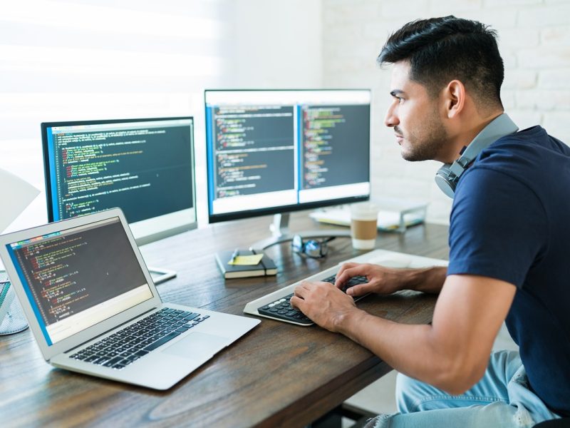 side-view-attractive-hispanic-software-developer-programming-using-computer-while-working-from-home (1)